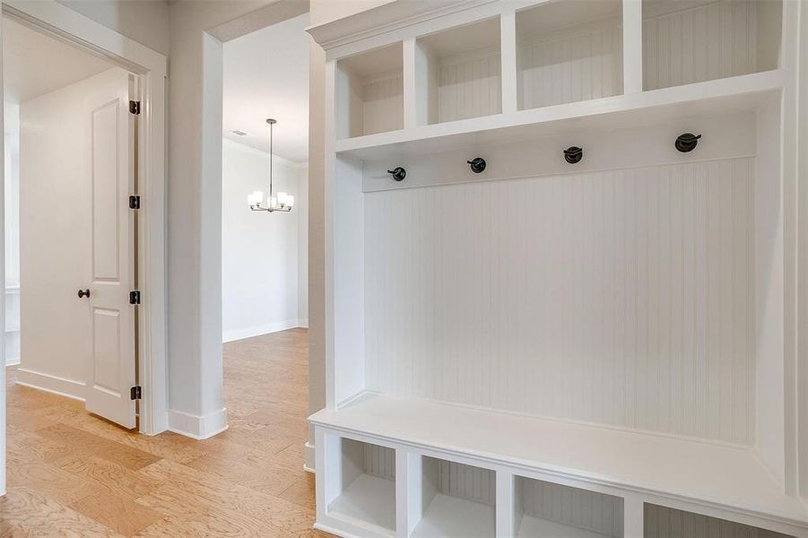 Mudroom with a notable chandelier and hardwood / wood-style flooring