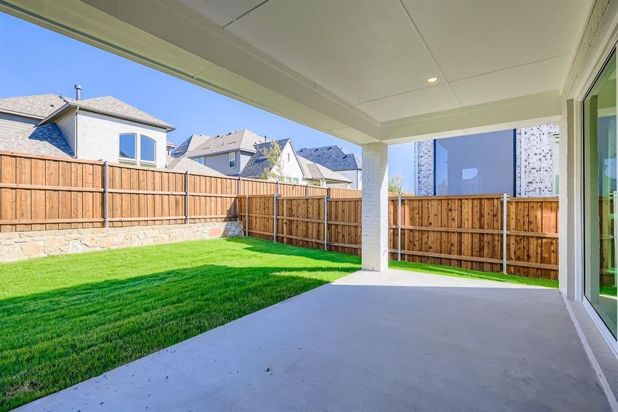 Fenced backyard with a patio area Fenced backyard with a patio area