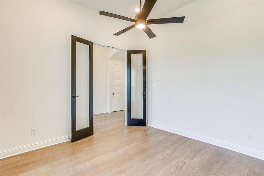 Spare room with french doors, light wood-type flooring, and ceiling fan