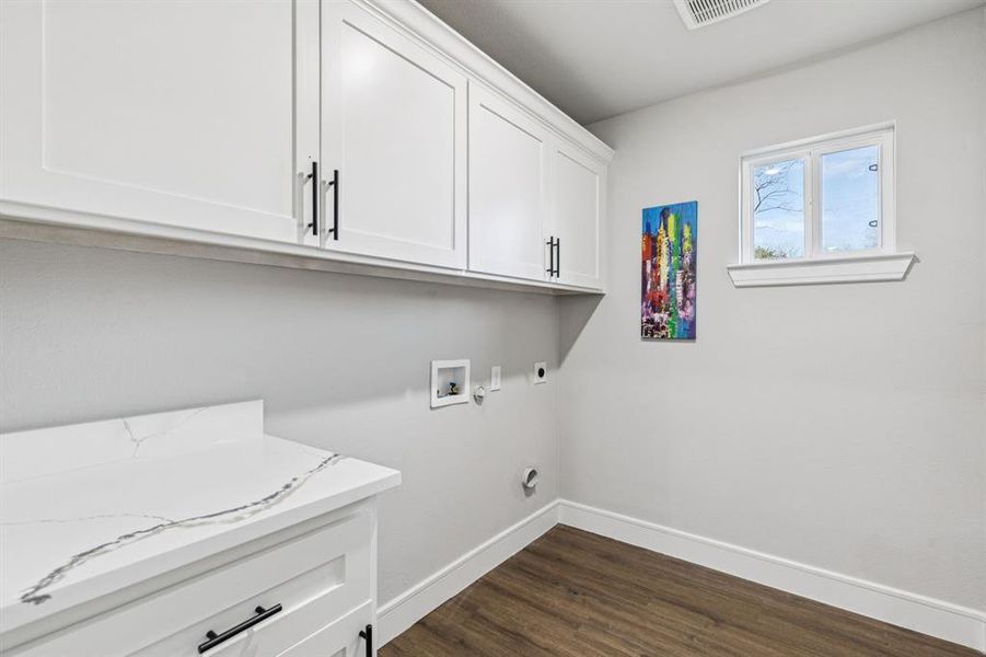 Laundry room with washer hookup, electric dryer hookup, dark wood-type flooring, and cabinet space