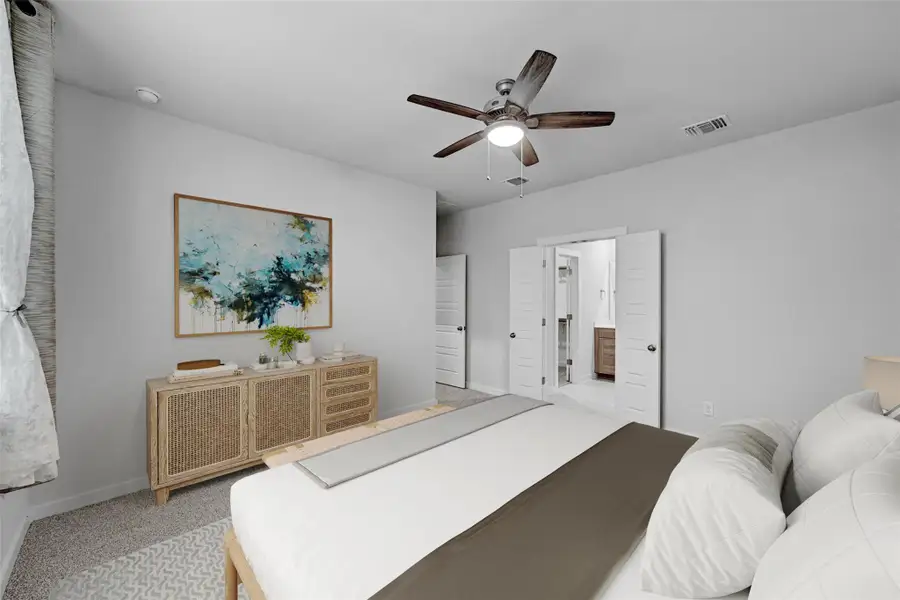 Carpeted bedroom featuring a ceiling fan and ensuite bath Carpeted bedroom featuring a ceiling fan and ensuite bath
