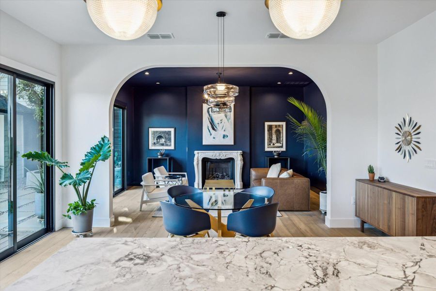 Dining space with archway to living room with antique marble fireplace Dining space with archway to living room with antique marble fireplace