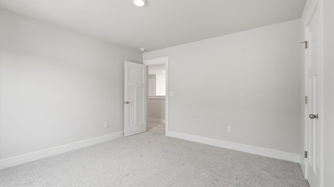 Accomplished design shines in this carpeted bedroom with a functional walk-in closet