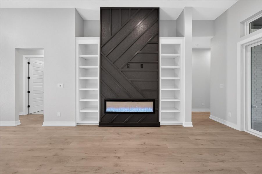 A modern fireplace focal point anchors the airy main living area with built-in shelving.