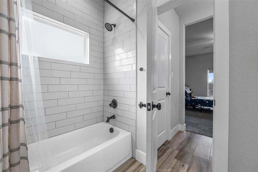 Bathroom featuring hardwood / wood-style flooring and shower / tub combo