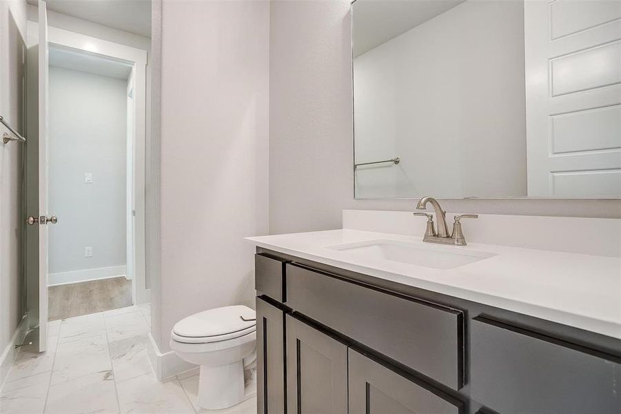 Bathroom with hardwood / wood-style floors, vanity, and toilet