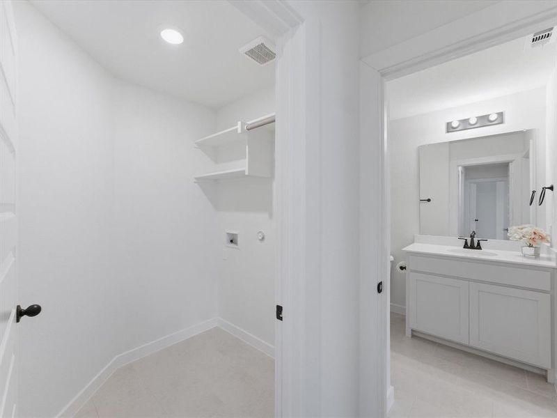Laundry area with recessed lighting, built-in shelving, and a hanging rod Laundry area with recessed lighting, built-in shelving, and a hanging rod