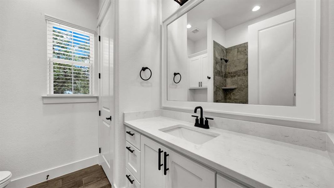 Bathroom with hardwood / wood-style flooring, vanity, and toilet