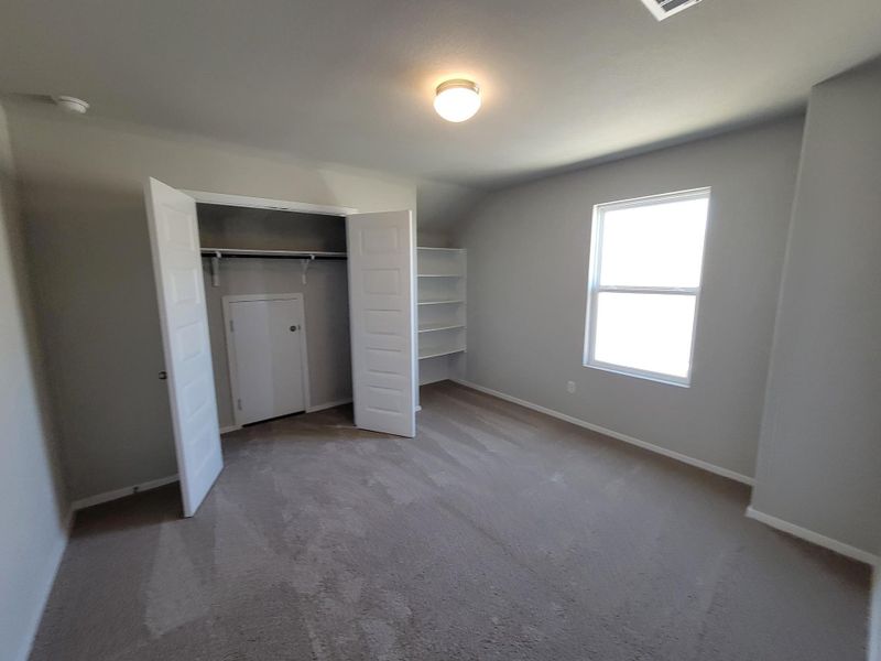 Unfurnished bedroom featuring vaulted ceiling, carpet floors, a closet, and baseboards