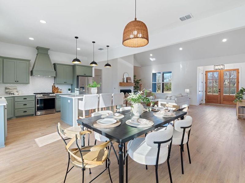 Dining room with french doors, recessed lighting, light wood-type flooring, and vaulted ceiling