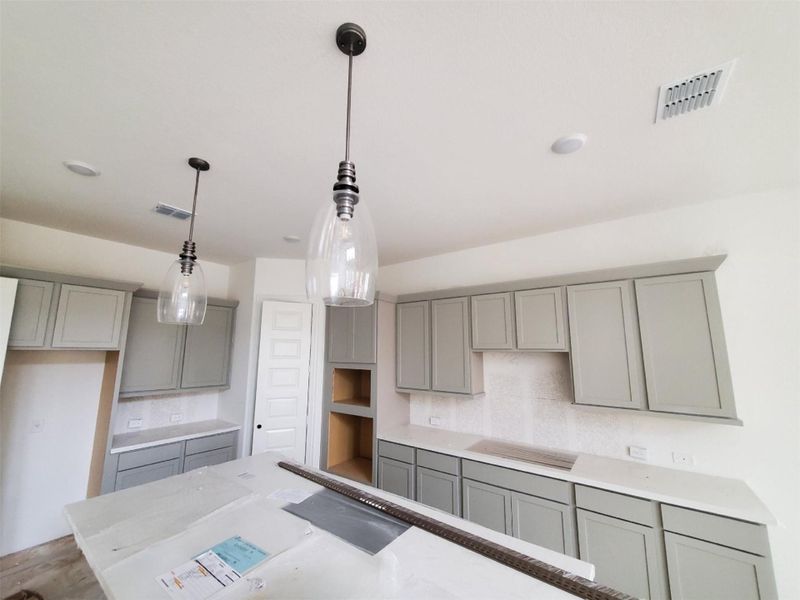 Kitchen with visible vents, gray cabinets, decorative light fixtures, and decorative backsplash