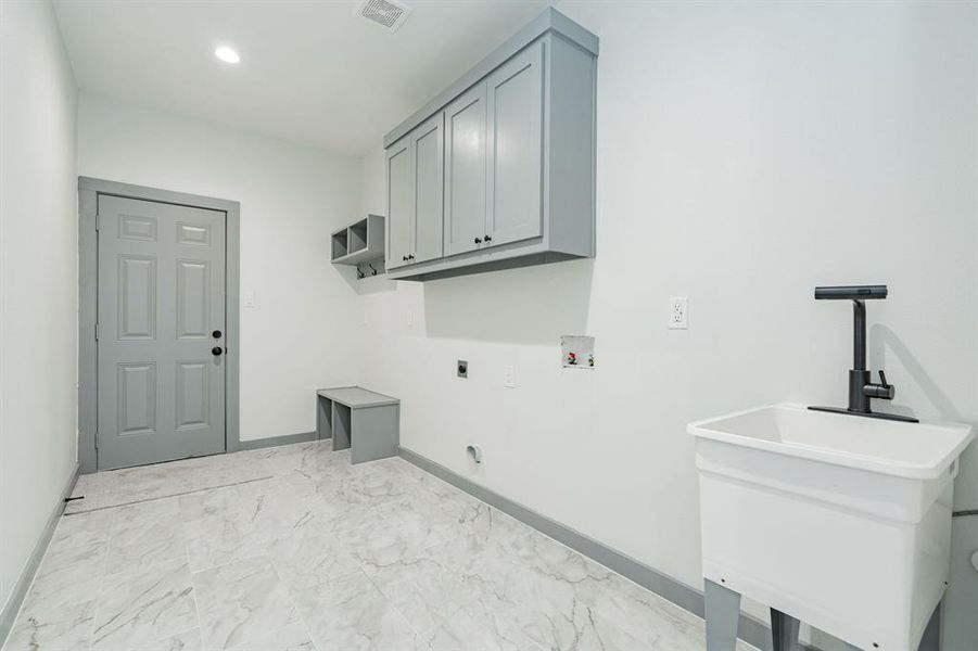 Laundry area with washer hookup, light tile patterned floors, cabinets, and hookup for an electric dryer