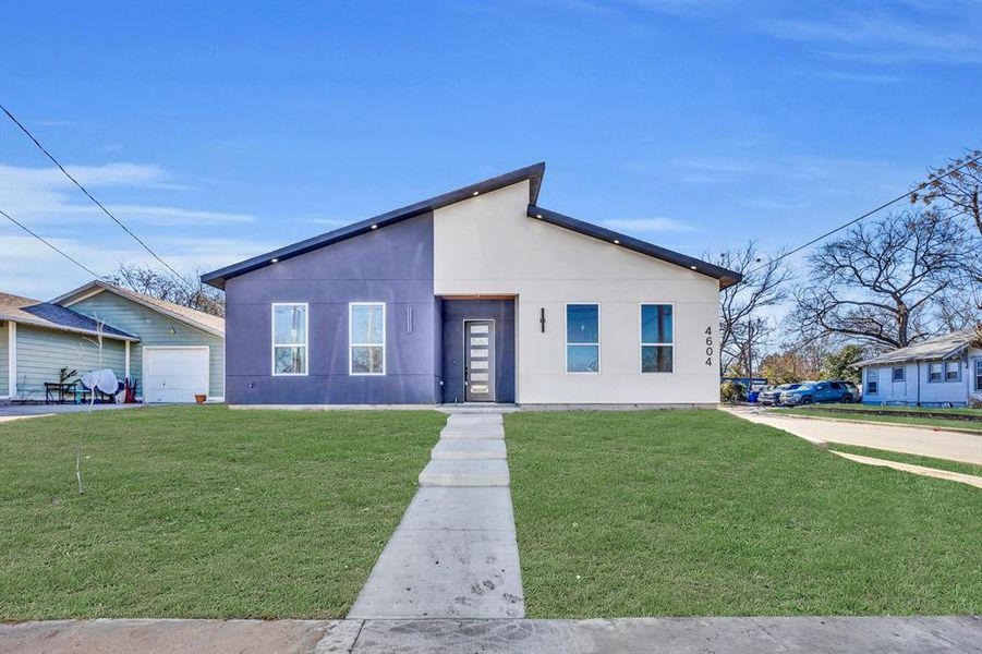 View of front of house with a garage and a front lawn