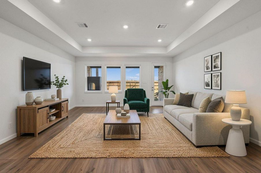 The living room opens into a bright central gathering space with elevated ceilings, recessed lighting, and large windows along the back of the home. Its connection to the kitchen and dining area gives the first floor a smooth, open rhythm. Virtually staged. The living room opens into a bright central gathering space with elevated ceilings, recessed lighting, and large windows along the back of the home. Its connection to the kitchen and dining area gives the first floor a smooth, open rhythm. Virtually staged.