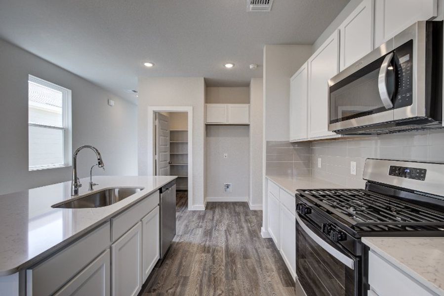 A kitchen with white cabinets.
