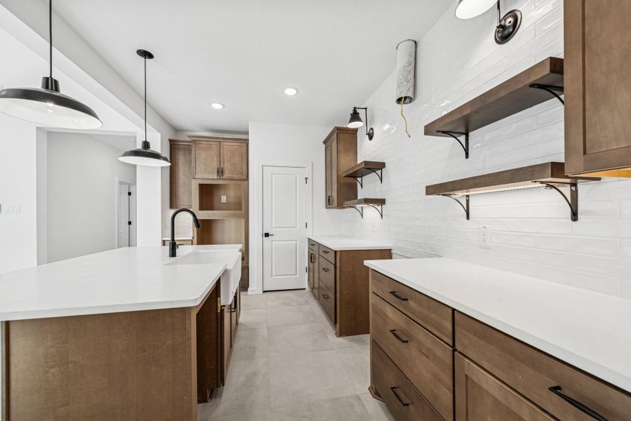 Lovely kitchen with chestnut brown cabinets and quartz counters