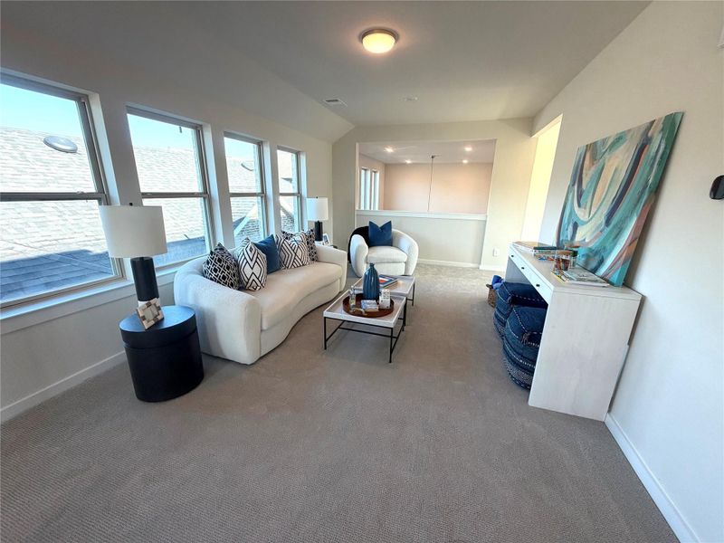 The game room features large windows that fill the space with natural light to gather with friends and family.