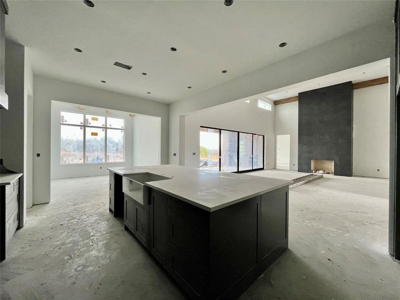 Kitchen with a large fireplace, a spacious island, and light stone countertops