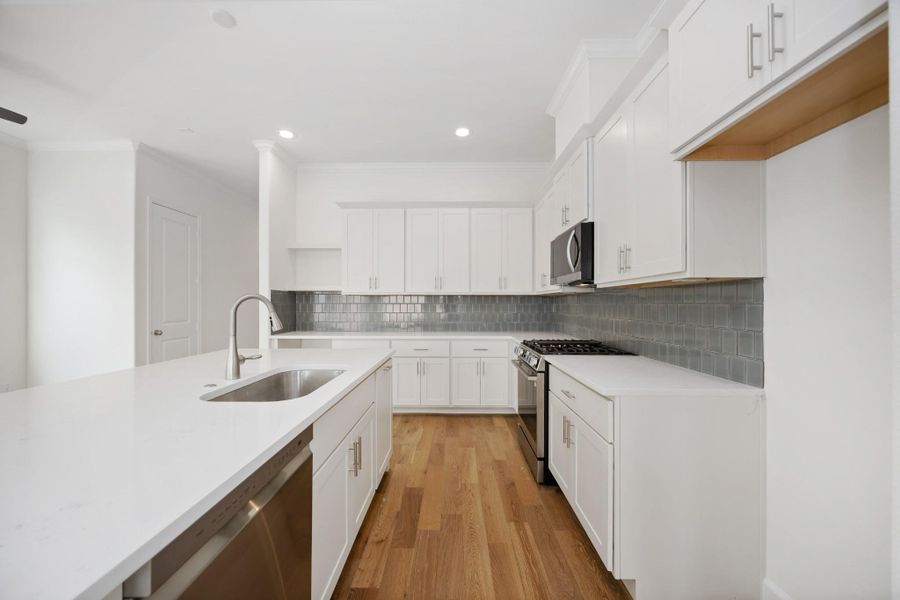 Designer Finishes Meet Everyday Function: Timeless meets trendy in this gourmet kitchen with Benedettini cabinets with soft-close drawers, quartz countertops, and custom design selections. The open layout keeps you connected to the living and dining spaces beyond.