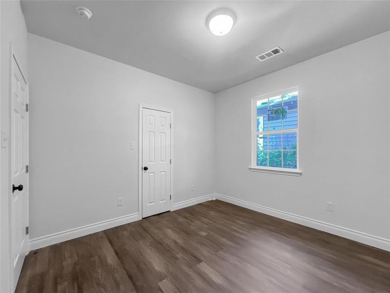 Unfurnished room with dark wood finished floors and baseboards Unfurnished room with dark wood finished floors and baseboards