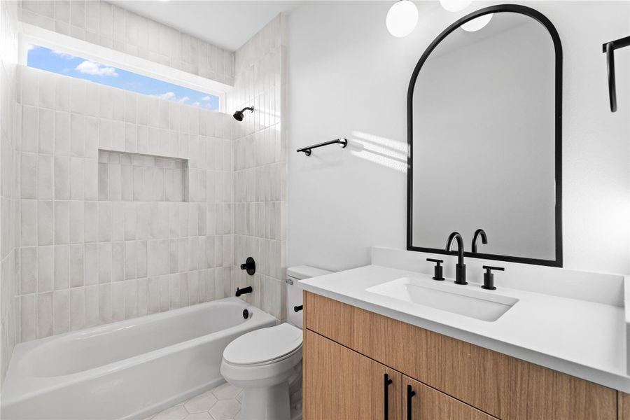 A crisp, modern retreat—this bathroom pairs soft, vertical tilework with bold matte black finishes and warm wood cabinetry. A sleek arched mirror, built-in shower niche, and clerestory window add architectural elegance while filling the space with natural light. A crisp, modern retreat—this bathroom pairs soft, vertical tilework with bold matte black finishes and warm wood cabinetry. A sleek arched mirror, built-in shower niche, and clerestory window add architectural elegance while filling the space with natural light.