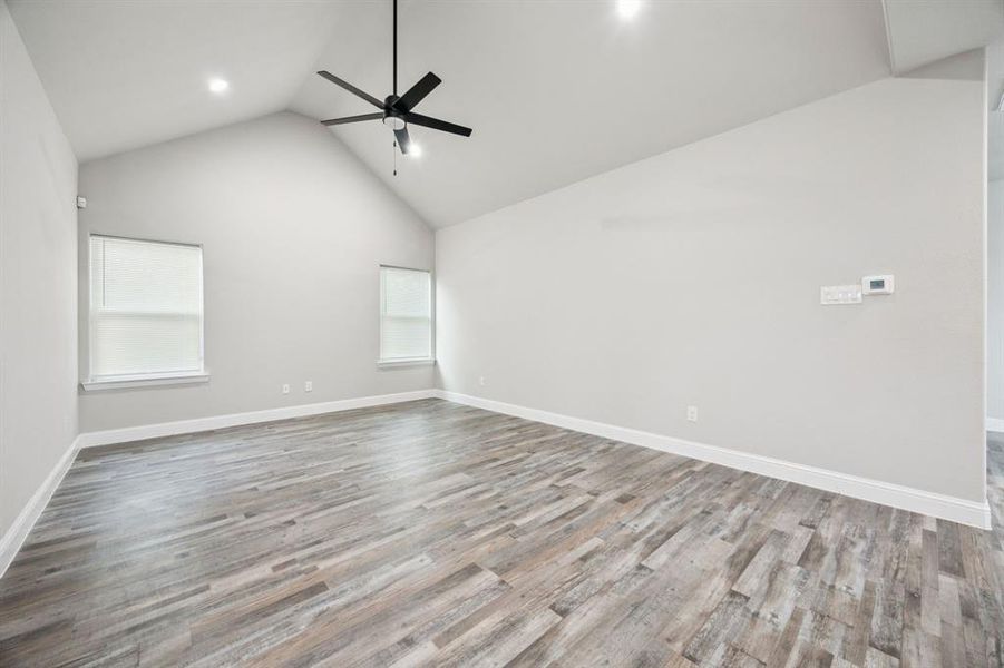 Family room with high vaulted ceiling, light wood-style flooring, and ceiling fan Family room with high vaulted ceiling, light wood-style flooring, and ceiling fan