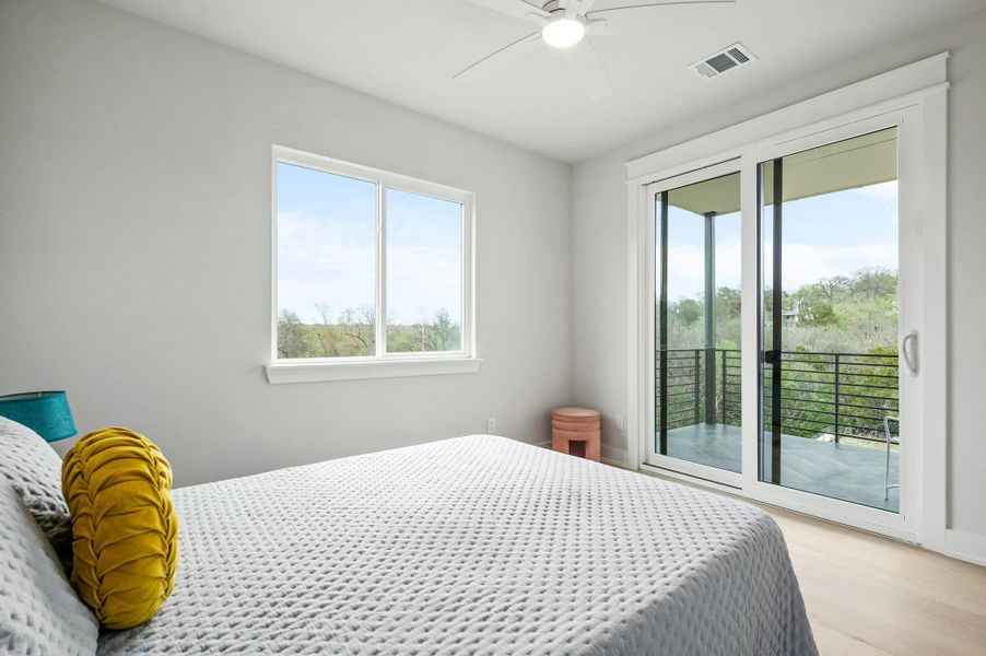 Bedroom #2 with wood finished floors, access terrace, and ceiling fan