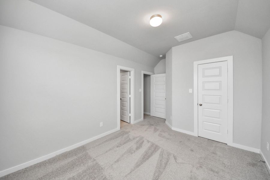 Secondary bedroom features plush carpeting, large windows that let in plenty of natural light, bright paint, and spacious closets.