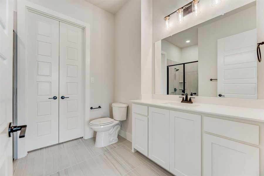 Bathroom featuring vanity, a stall shower, and light tile patterned flooring Bathroom featuring vanity, a stall shower, and light tile patterned flooring