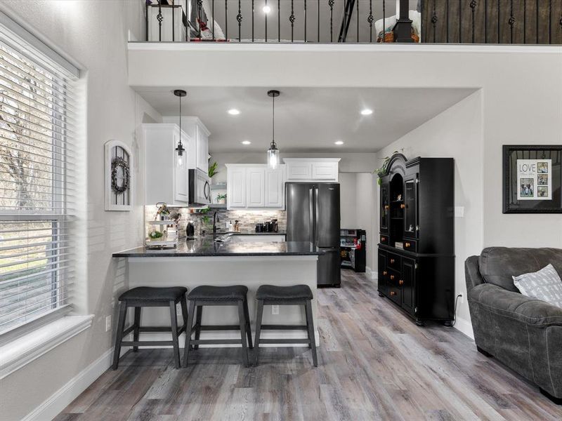 Kitchen featuring white cabinetry, a peninsula, a wealth of natural light, and appliances with stainless steel finishes