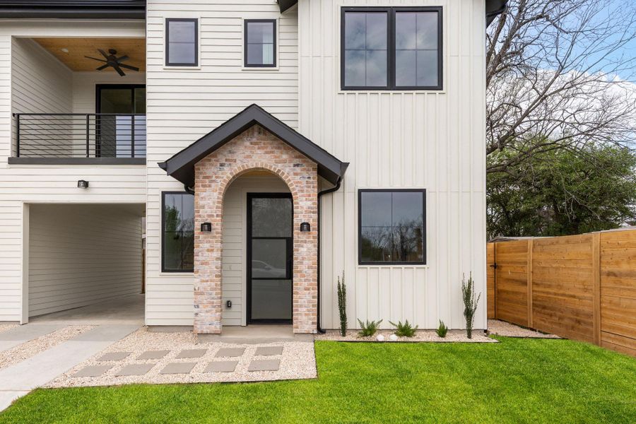 View of front of property featuring board and batten siding, a balcony, and a ceiling fan