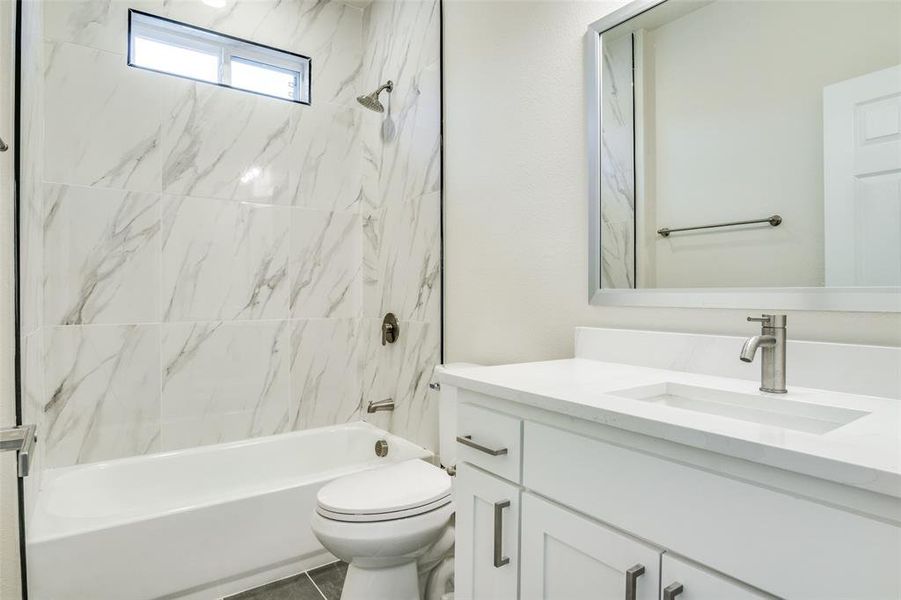 Bathroom featuring vanity, shower / bathtub combination, and toilet
