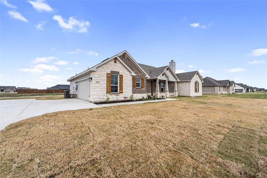 View of front of property featuring a chimney, driveway, stone siding, a porch, and a garage View of front of property featuring a chimney, driveway, stone siding, a porch, and a garage