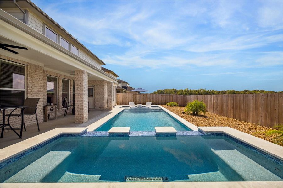 Beautiful backyard featuring a modern in-ground heated saltwater pool with built-in seating, a spacious patio area with outdoor seating, and a privacy fence. Beautiful backyard featuring a modern in-ground heated saltwater pool with built-in seating, a spacious patio area with outdoor seating, and a privacy fence.