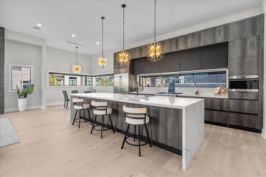 An oversized quartz island seats six and pairs beautifully with Wolf appliances and a Sub-Zero refrigerator — all included.