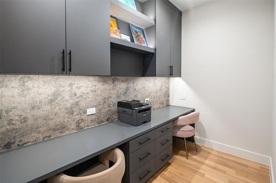 Versatile tech room featuring custom built-in desks, abundant cabinetry for storage, and a stylish accent wall backsplash. This flexible space is ideal for a kids’ study area, second office, craft room, or creative workspace while keeping everything organized and functional.