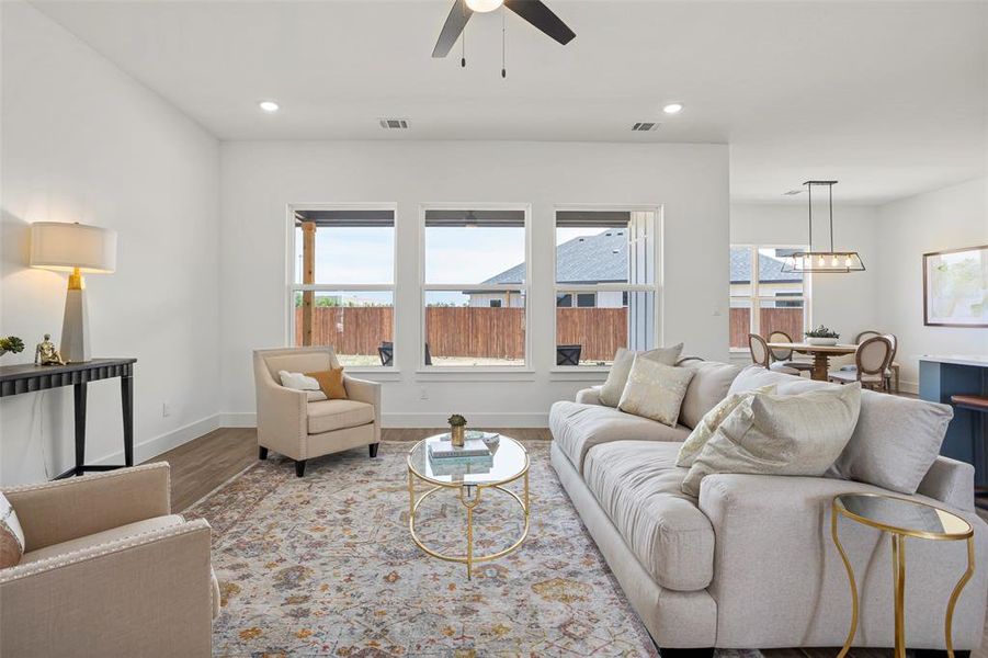Living room featuring hardwood / wood-style floors and ceiling fan with notable chandelier