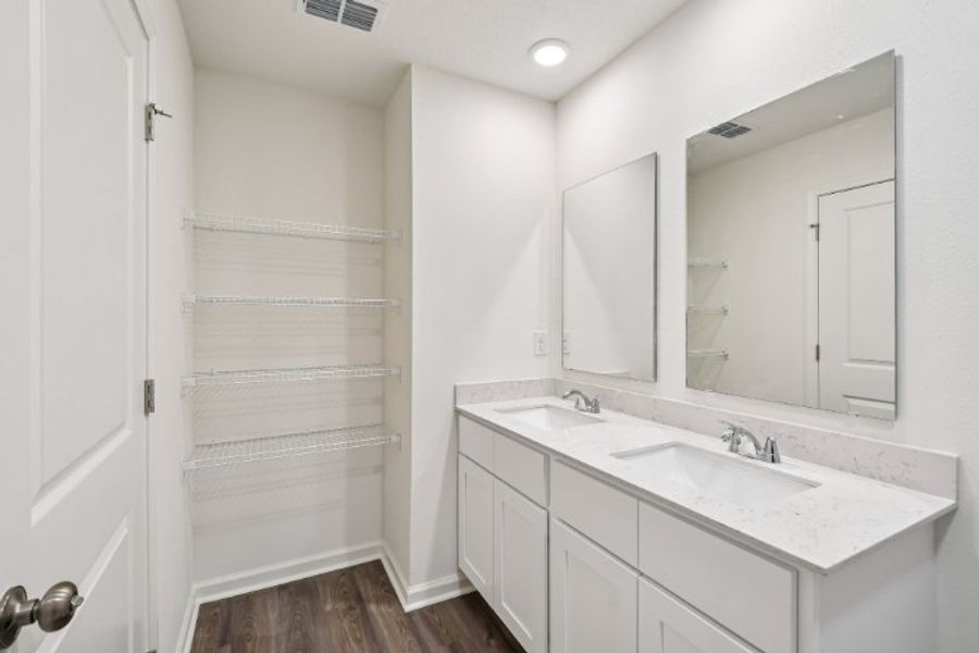 A bathroom with white cabinets.