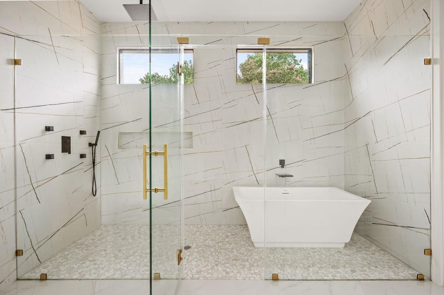 A lavish primary bathroom offers a spacious walk-in shower and a free-standing soaking tub. A lavish primary bathroom offers a spacious walk-in shower and a free-standing soaking tub.