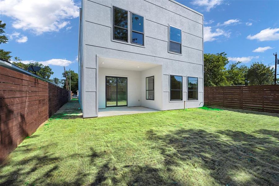 Back of house with a yard and a patio