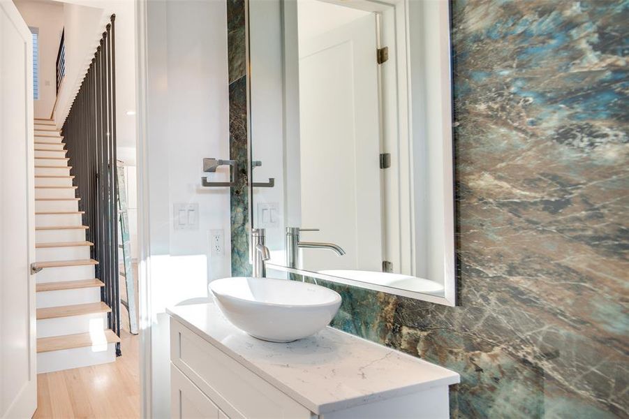 Bathroom featuring vanity, backsplash, and wood-type flooring