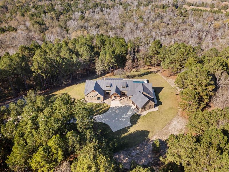Aerial view of property's location with a heavily wooded area