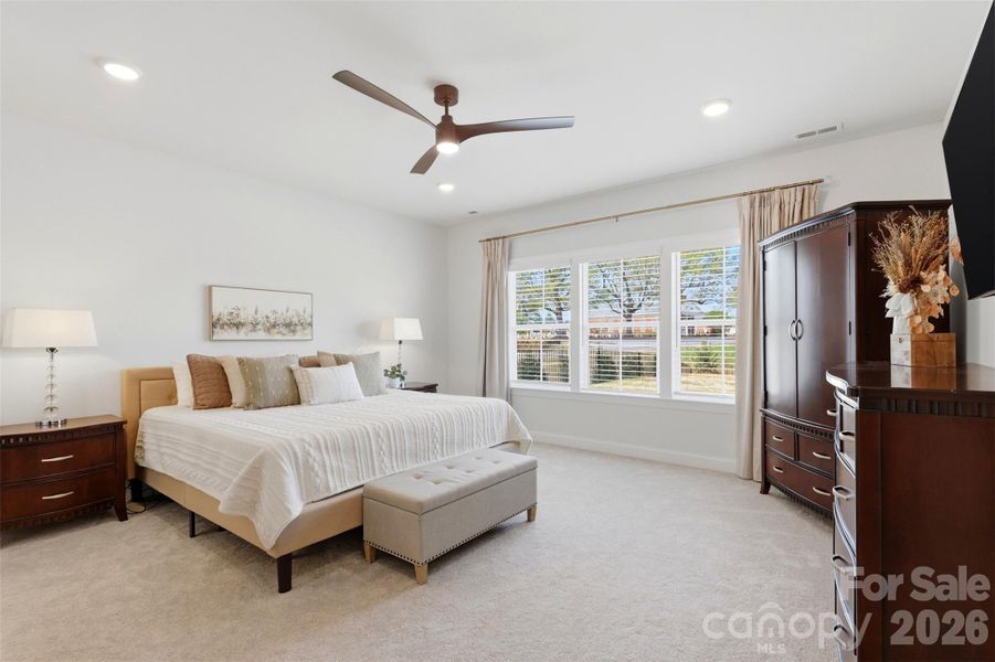 Spacious owner’s suite on main level featuring a serene atmosphere, abundant natural light, and room to unwind in comfort.