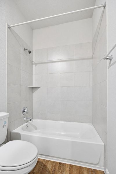Full bath with bathtub / shower combination and wood finished floors