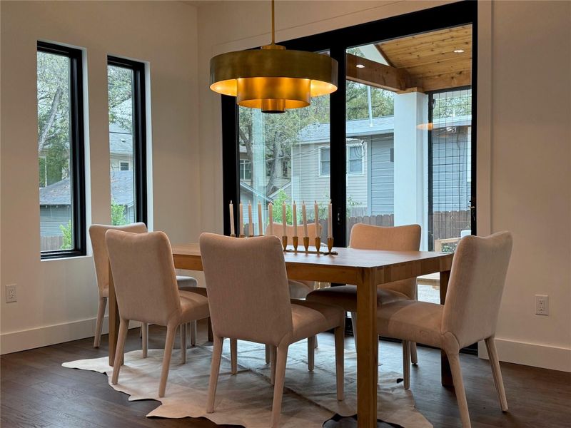 Dining space featuring dark wood-style floors and healthy amount of natural light Dining space featuring dark wood-style floors and healthy amount of natural light