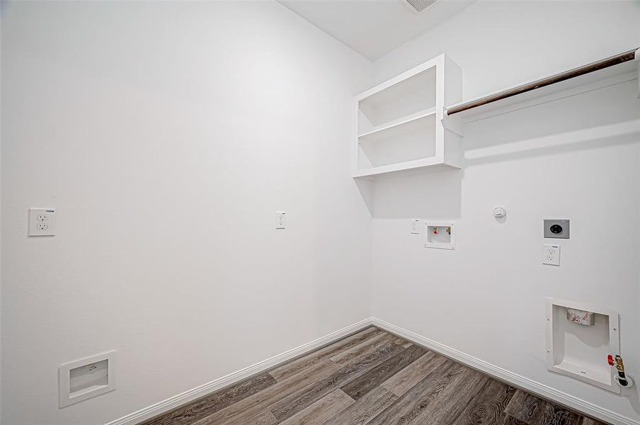 Off the kitchen, a spacious laundry room offers built-in cabinets and a hanging rack.