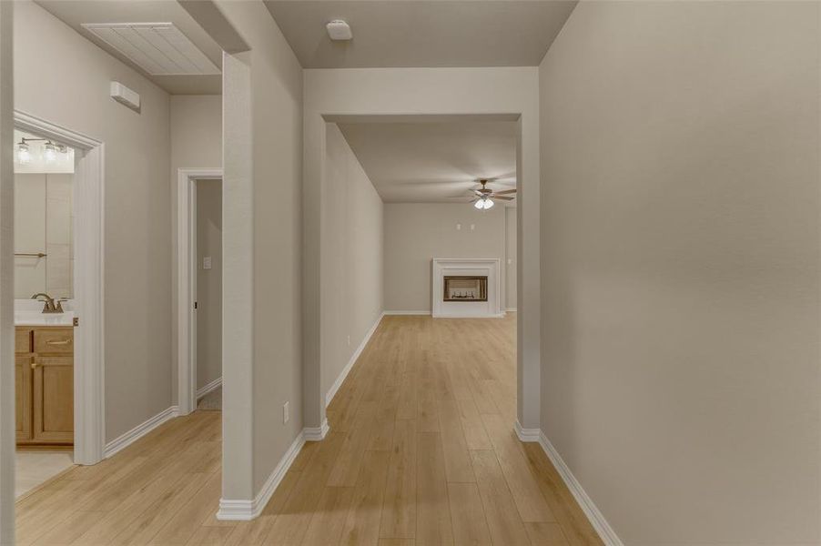Open concept interior with light wood-finish flooring, neutral wall paint, and white baseboards