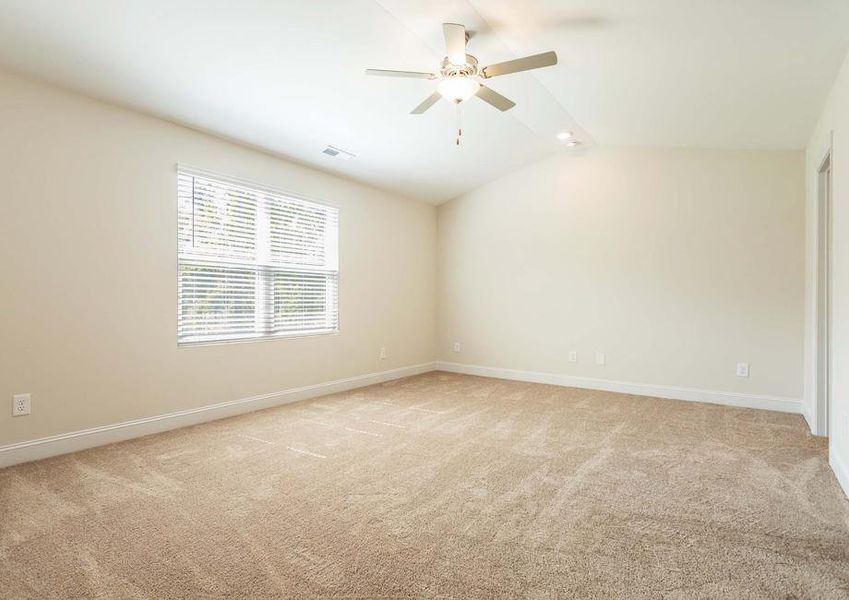 Spacious master bedroom with a ceiling fan and a large window.