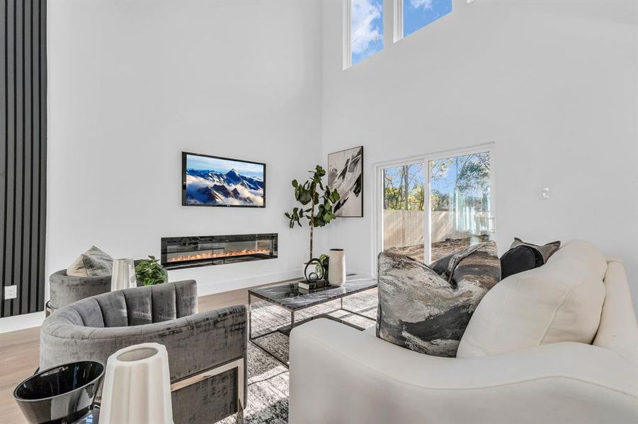 Living room featuring a towering ceiling and hardwood / wood-style flooring