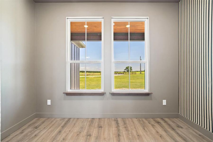 Interior office space featuring two large windows with white frames and wood-finish sills. A great space to get some work done while still enjoying the scenery and natural lighting.